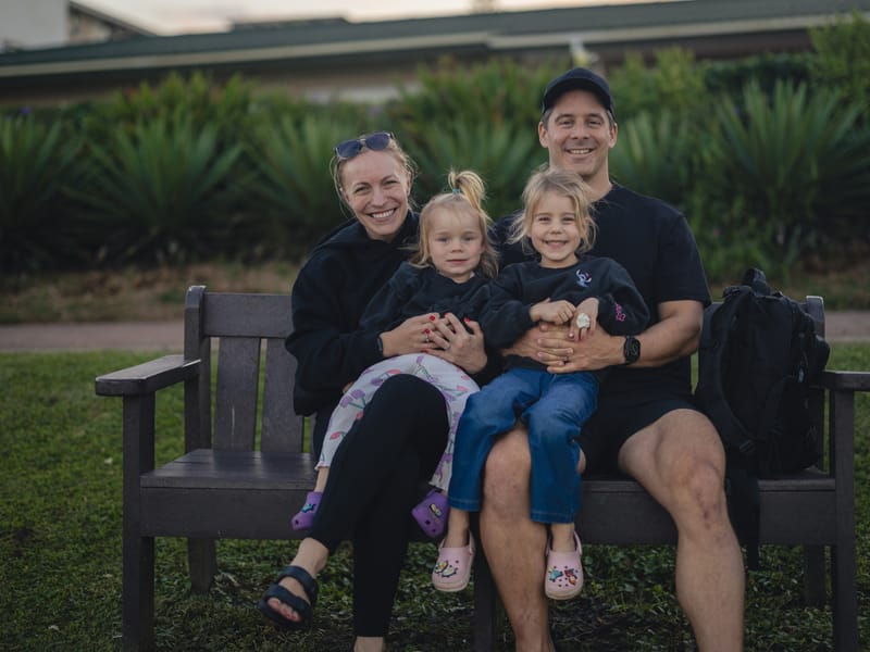 Cédric, Elena and their two girls on a park bench at sunset